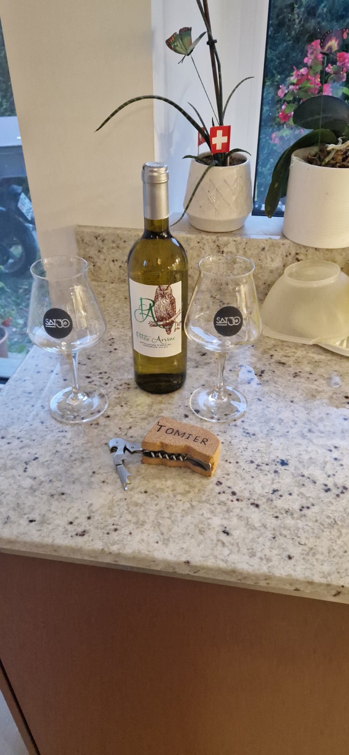 Premier Tomier posé près d’une bouteille et de deux verres après l’essai d’ouverture.